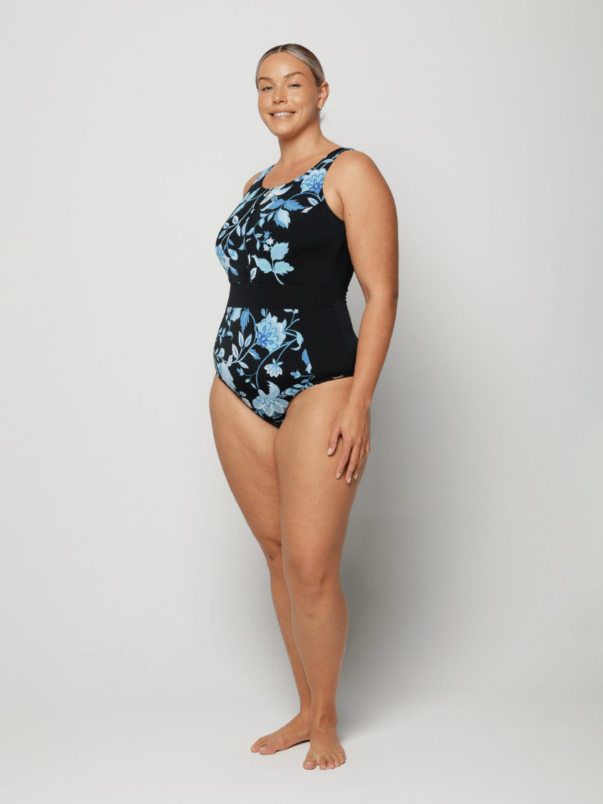 Woman wearing a black floral one-piece swimsuit on a white background