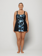 Woman wearing a black swimsuit with blue floral pattern on a white background