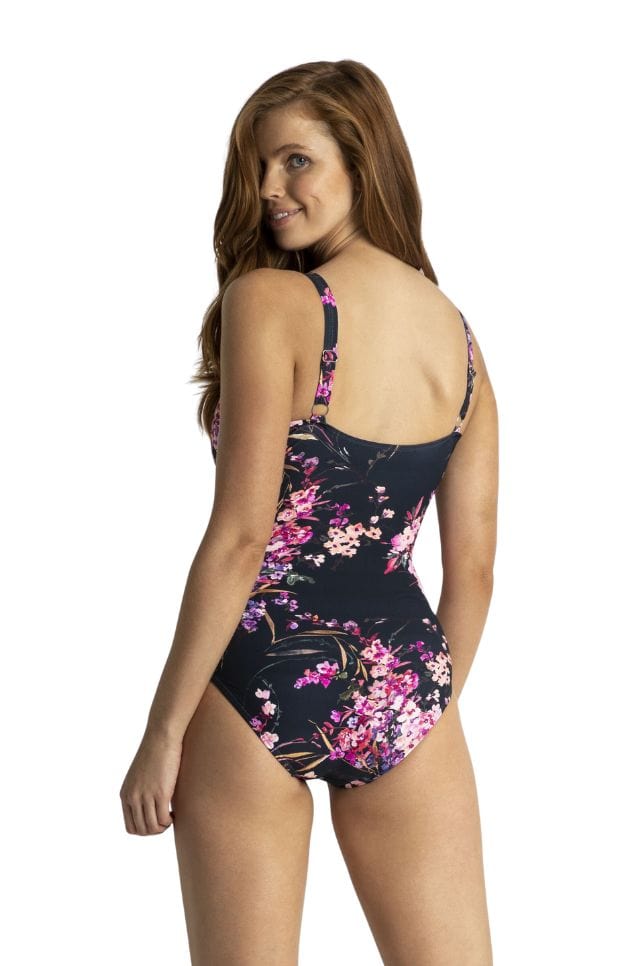 Back of plus size model wearing frill one piece with adjustable straps in navy, pink and purple tones