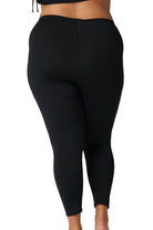 Back of model wearing modest long length swim pant for curve women