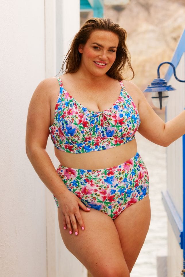 Brunette model wearing bright coloured high waisted swim pant for curve women