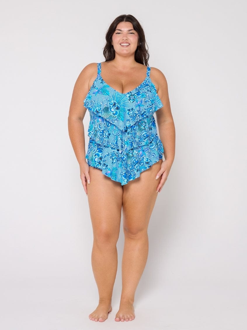 Woman wearing a blue floral swimsuit against a white background