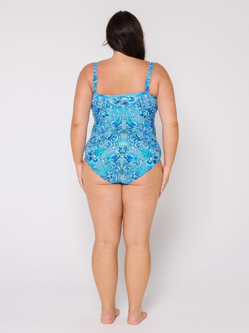 Woman wearing a blue patterned swimsuit on a white background
