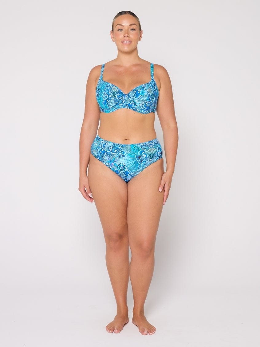 Woman wearing a blue floral bikini set on a white background
