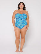 Woman wearing a blue strapless swimsuit with a pattern on a white background