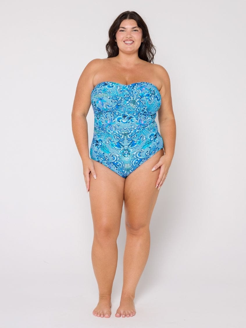 Woman wearing a blue strapless swimsuit with a pattern on a white background