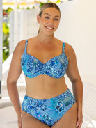 Woman wearing a blue patterned bikini set with a blurred outdoor background