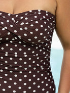 Brown strapless top with white polka dots on a blurred background