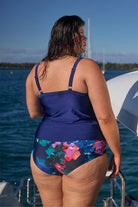 Back of brunette model wearing tiered tankini top with adjustable straps for plus size women