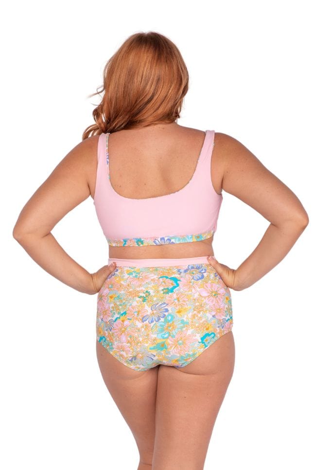 Curve women facing backwards wearing flattering multi pastel coloured floral pant 