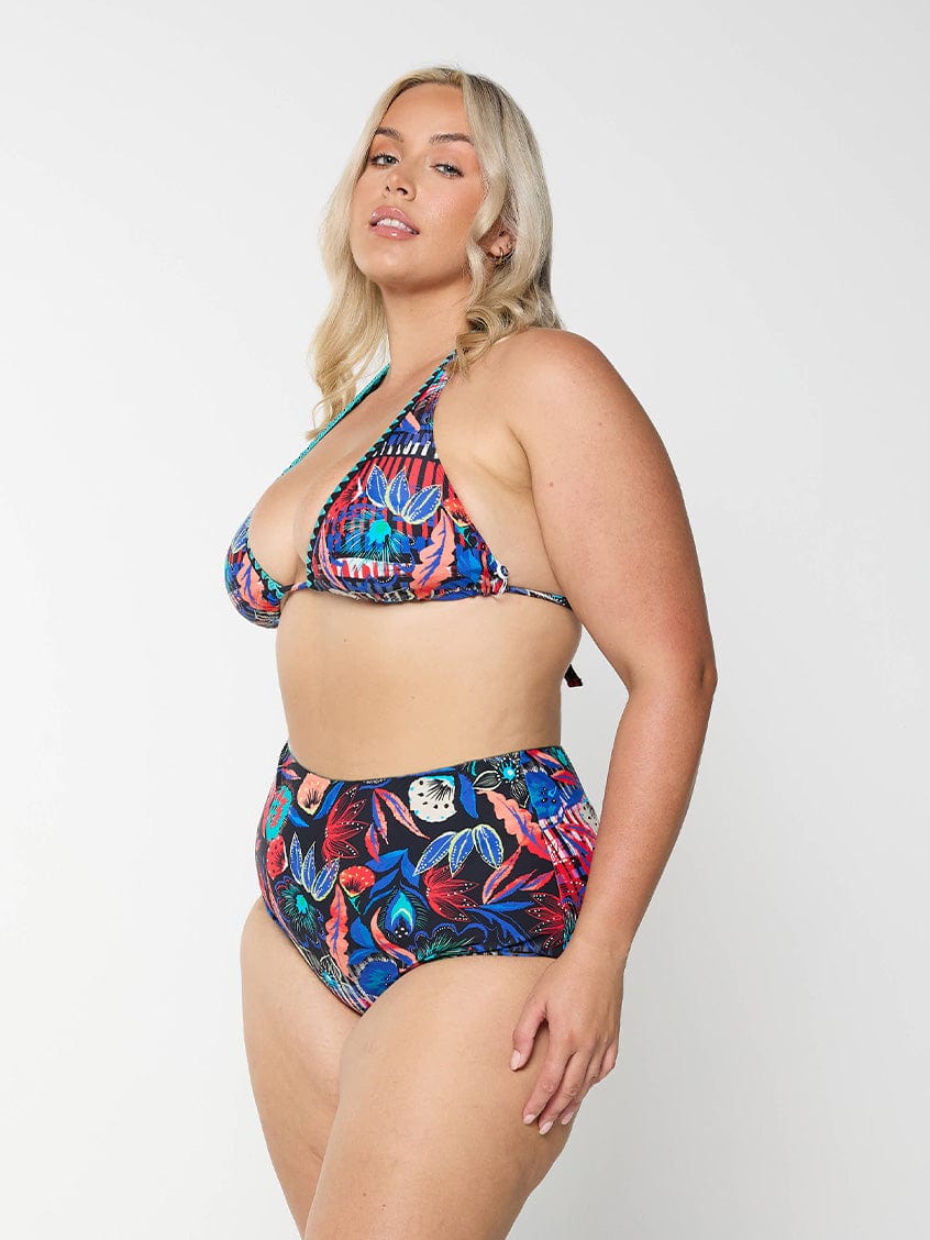 Side profile of curve model in studio wearing tie up triangle bikini top in embroidered multi colour