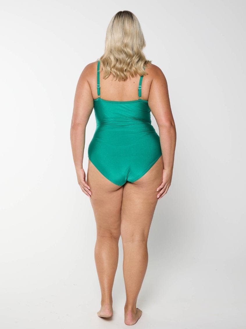 Woman wearing a green swimsuit on a white background