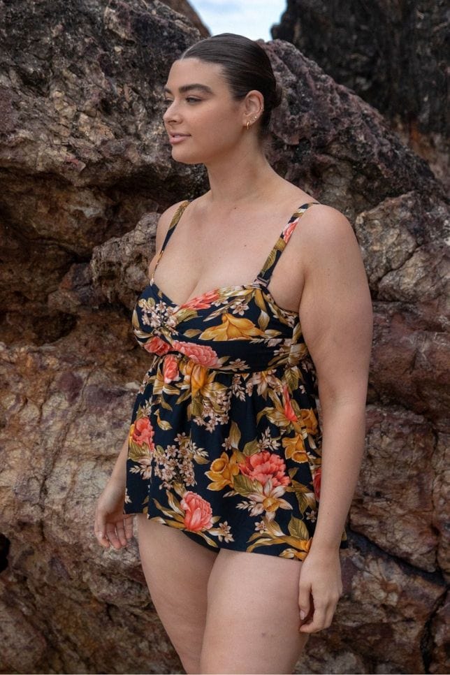 side profile of model wearing a black floral swing style tankini top 