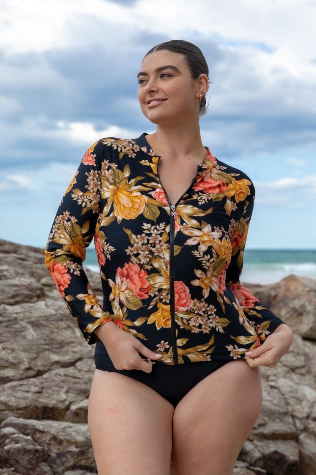Plus size model wearing floral long sleeve rash vest with zip on the beach Australia