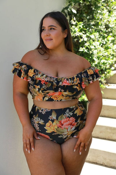 model wearing a off the shoulder frilled black floral bikini top and matching pant