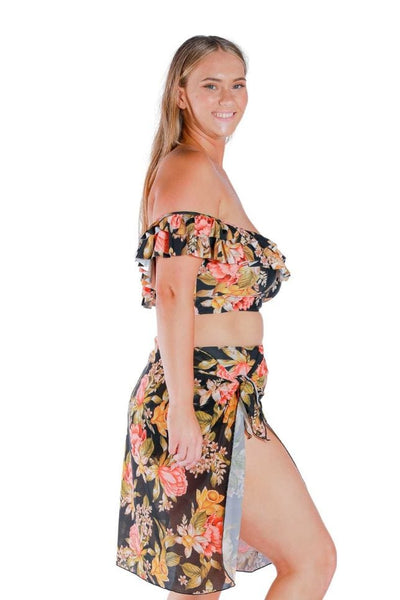 Side of model wearing mesh swim skirt in black based floral print for curvy women