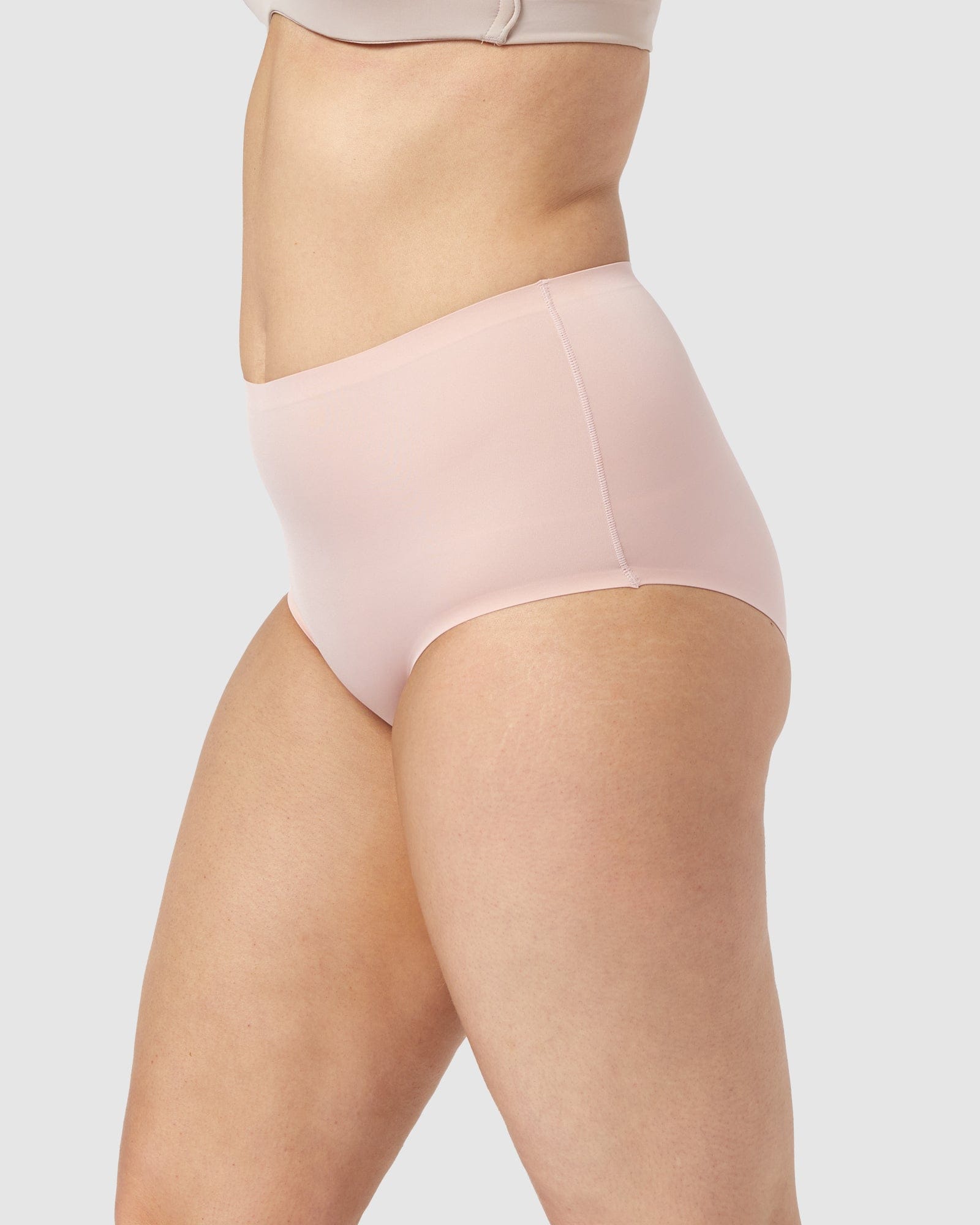 Light pink high-waisted underwear worn by a person on a light gray background