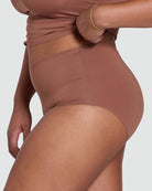 Brown high-waisted brief worn by a person on a white background