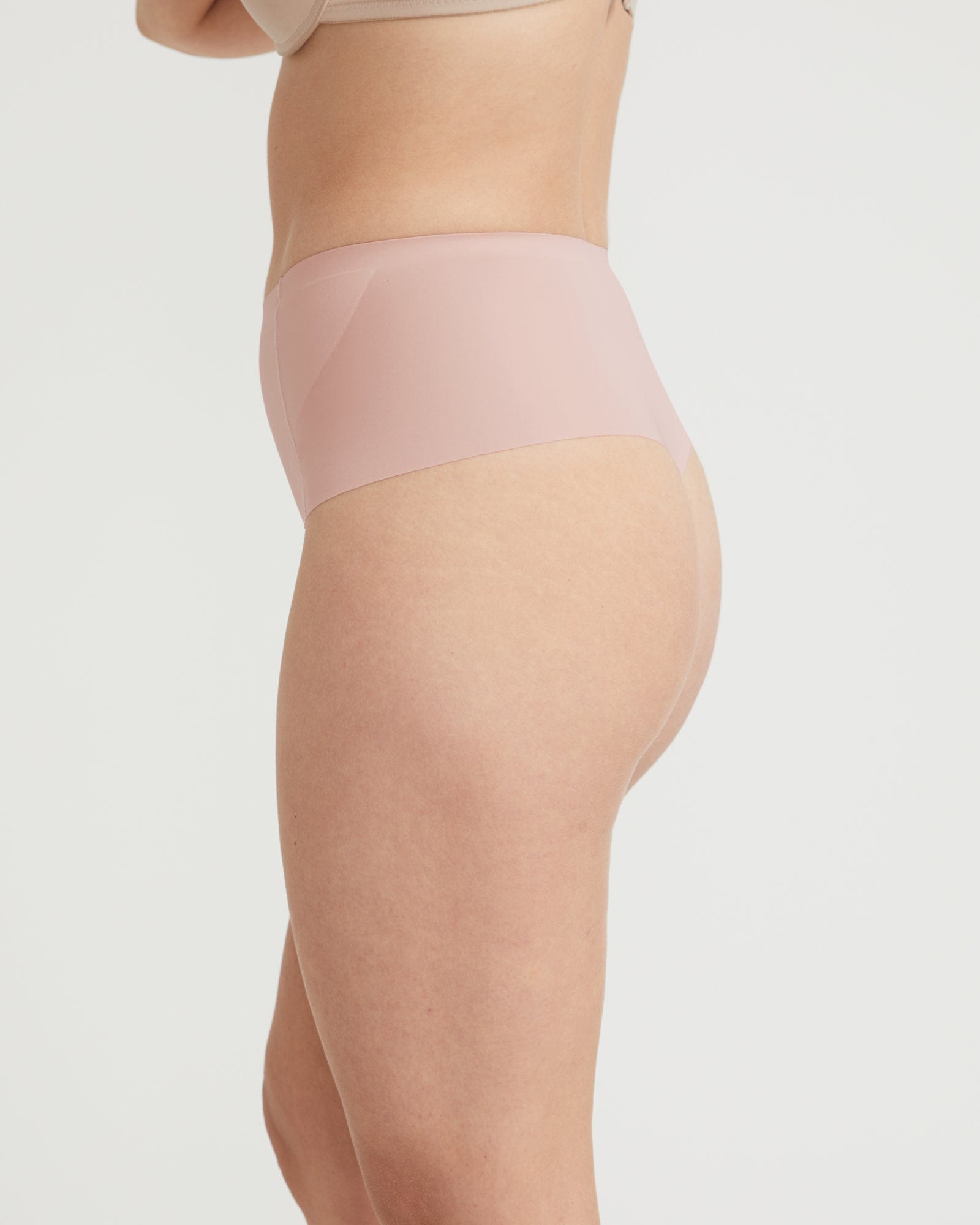 Beige shapewear being worn on a plain background
