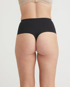 Black underwear worn by a person on a light gray background