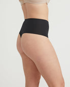 Person wearing black high-waisted underwear on a plain background