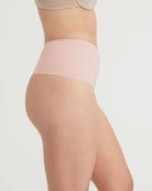 Light pink tights worn by a person on a plain background