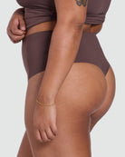 Person wearing a brown swimsuit on a white background
