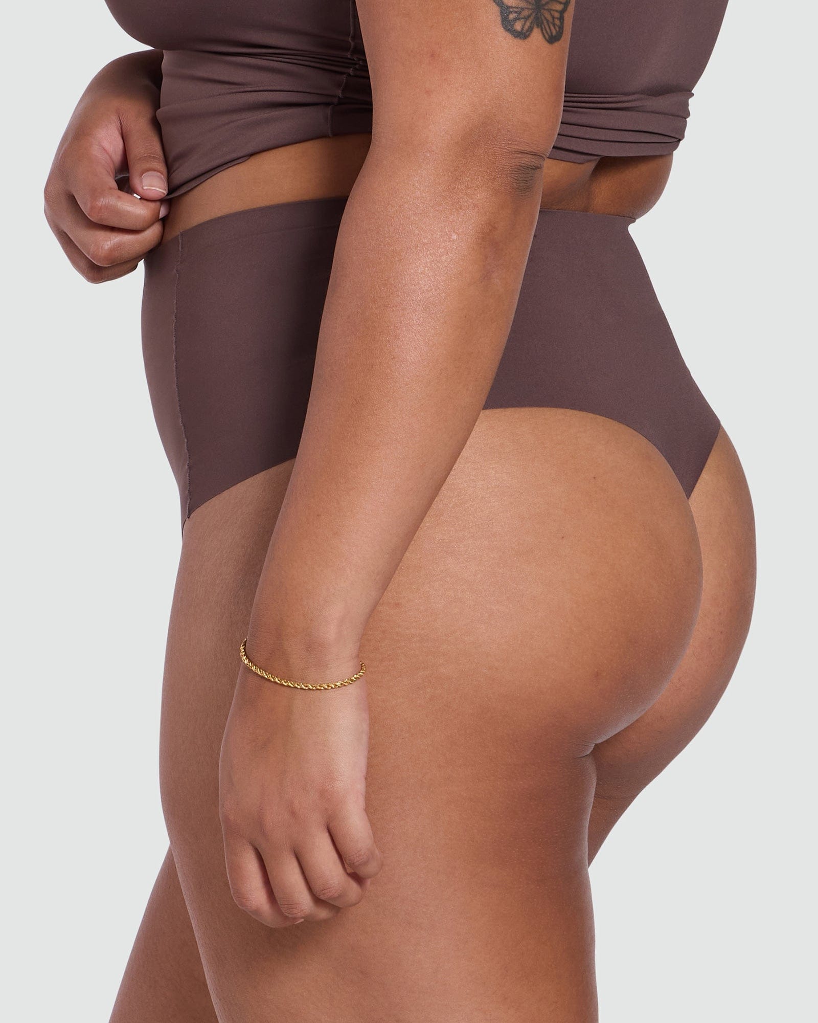 Person wearing a brown swimsuit on a white background