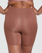 Brown shapewear shorts worn by a person on a plain background