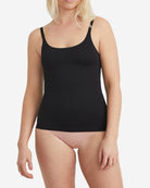 Person wearing a black tank top against a white background