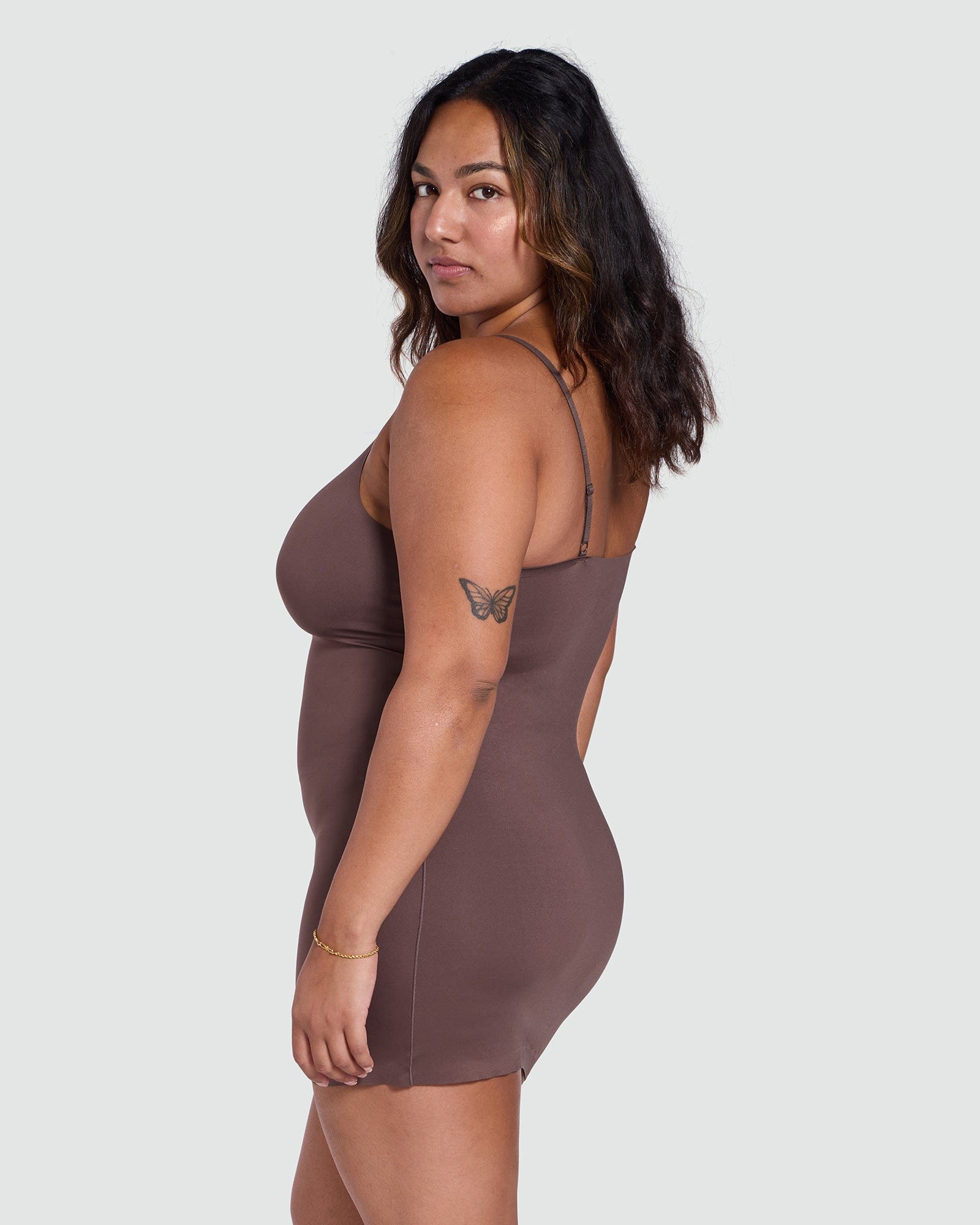 Woman wearing a brown dress against a white background