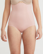 Person wearing a light pink bodysuit on a plain background