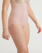 Person wearing a light pink bodysuit against a plain background