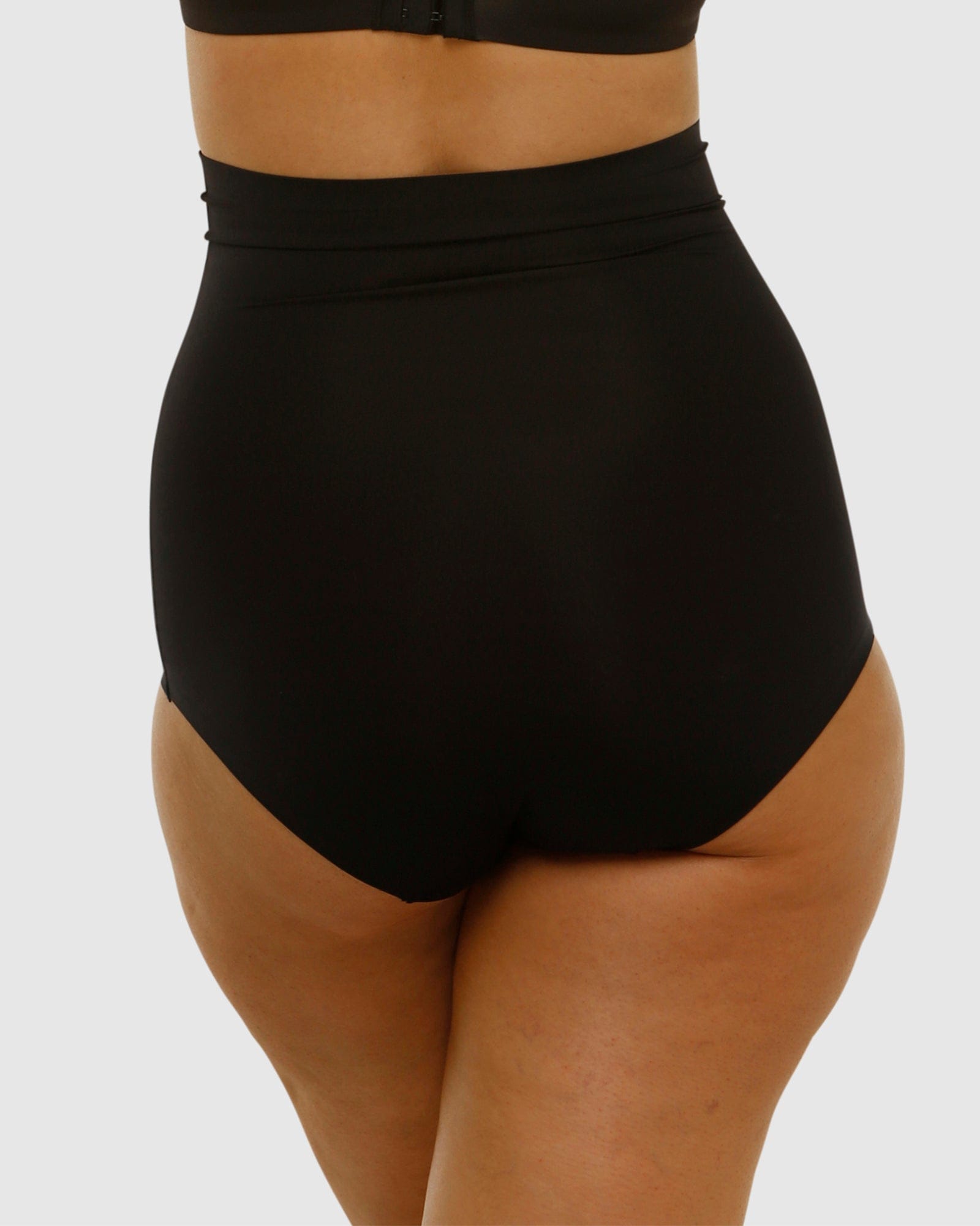 Black high-waisted swimsuit bottom on a plain background