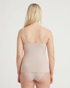 Woman wearing a beige tank top and underwear set on a plain background