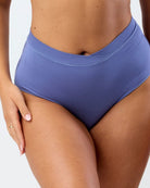 Blue high-waisted bikini bottom worn by a person on a plain background