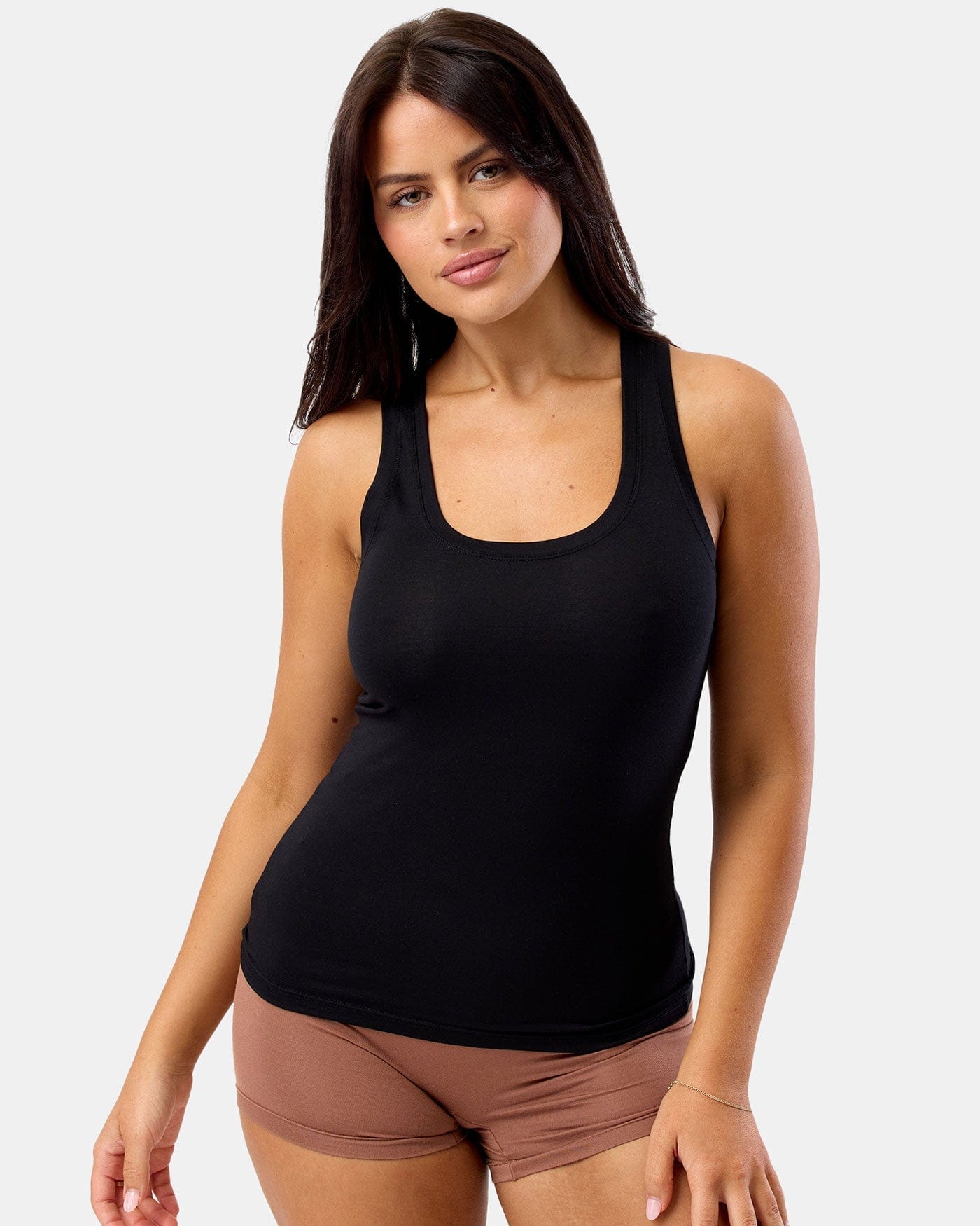 Woman wearing a black tank top and brown shorts on a white background