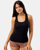 Woman wearing a black tank top and brown shorts on a white background