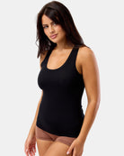 Woman wearing a black tank top against a plain background
