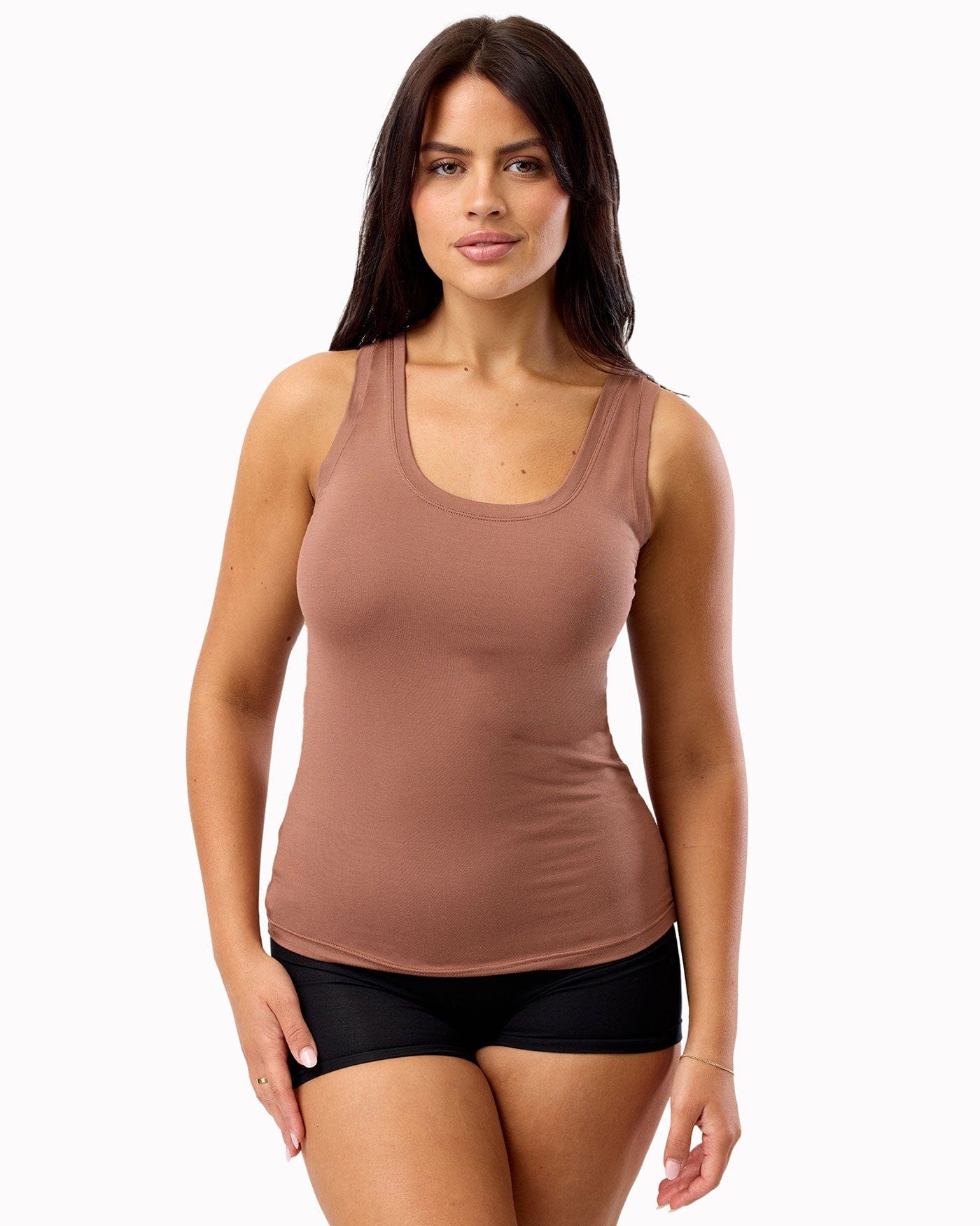 Woman wearing a brown tank top and black underwear on a white background