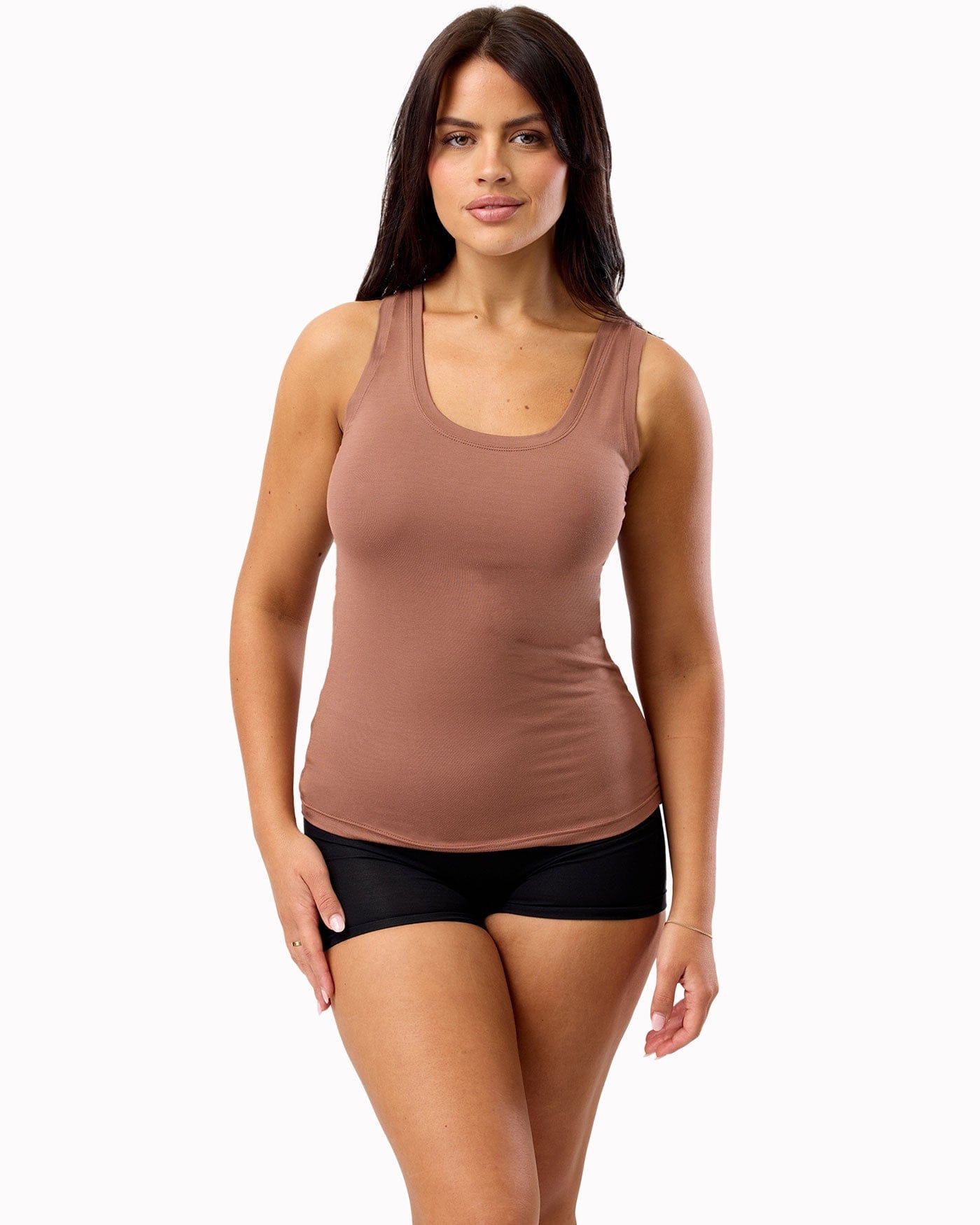 Woman wearing a brown tank top and black shorts on a white background