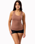 Woman wearing a brown tank top and black shorts on a white background
