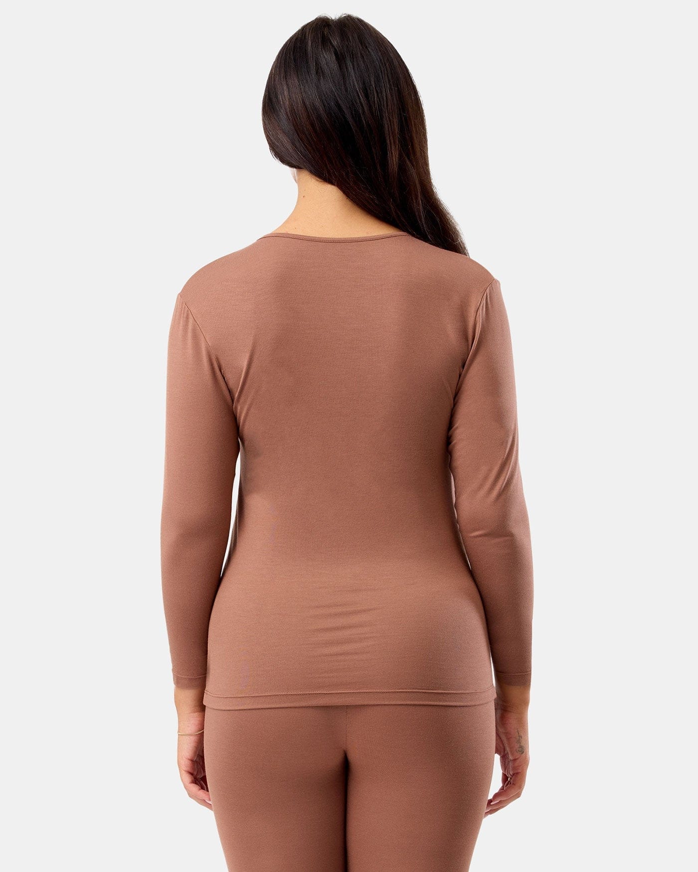 Brown long-sleeve top and leggings worn by a person on a white background