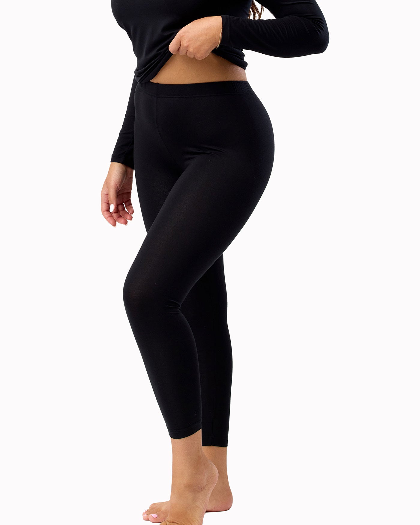 Person wearing black leggings on a white background