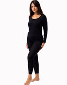Woman wearing a black long-sleeve top and leggings on a white background