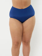 model in studio wearing navy high waisted swim pant
