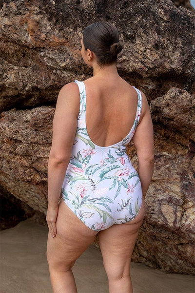 Woman wearing low scoop back plus size floral jantzen one piece swimsuit