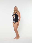 Woman wearing a floral one-piece swimsuit on a white background
