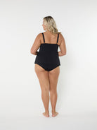 Woman wearing a black swimsuit on a white background