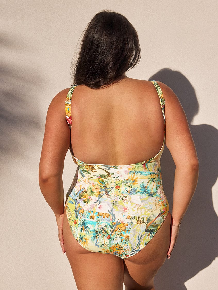 Woman wearing a floral swimsuit against a neutral background